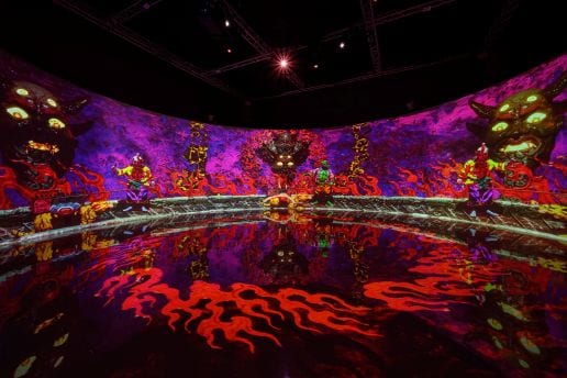 Purple and red projected demons cover an empty room and reflect across its dark floor.