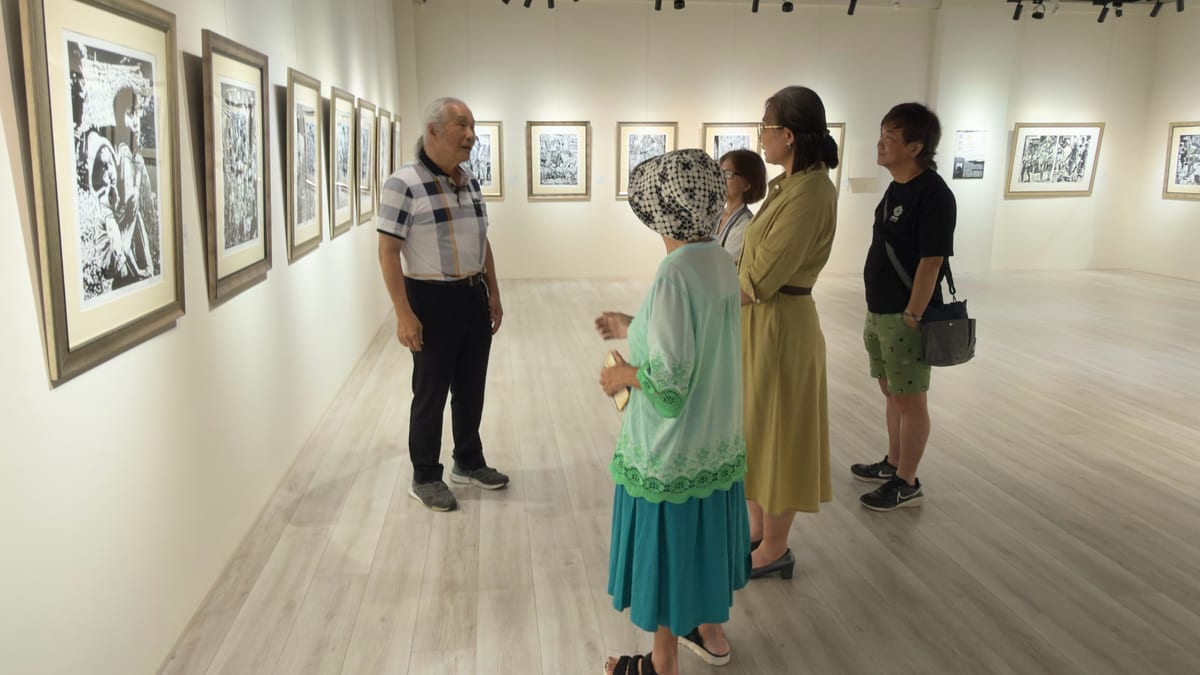 August 16 opening photograph: Liu Zhen-kun and several visitors stand in a white gallery surrounded by framed black-and-white woodcuts.
