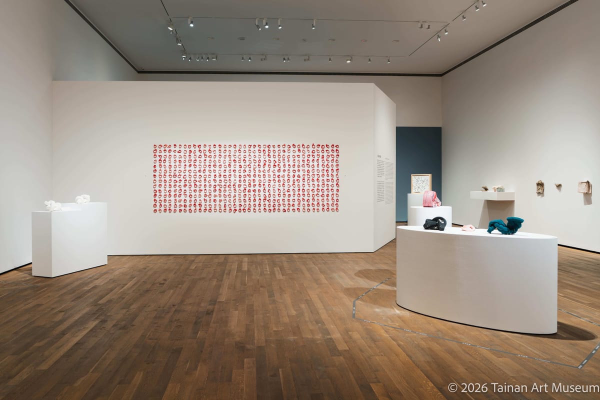 Repeated red forms, numbered knot-like ceramics, soft folded objects and small wall pieces share one room.