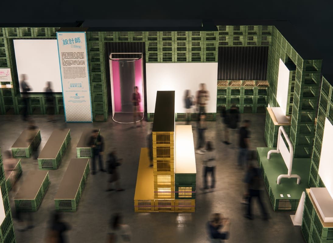 Exhibition preview: green produce crates form walls, benches and counters, with yellow crates at the centre.