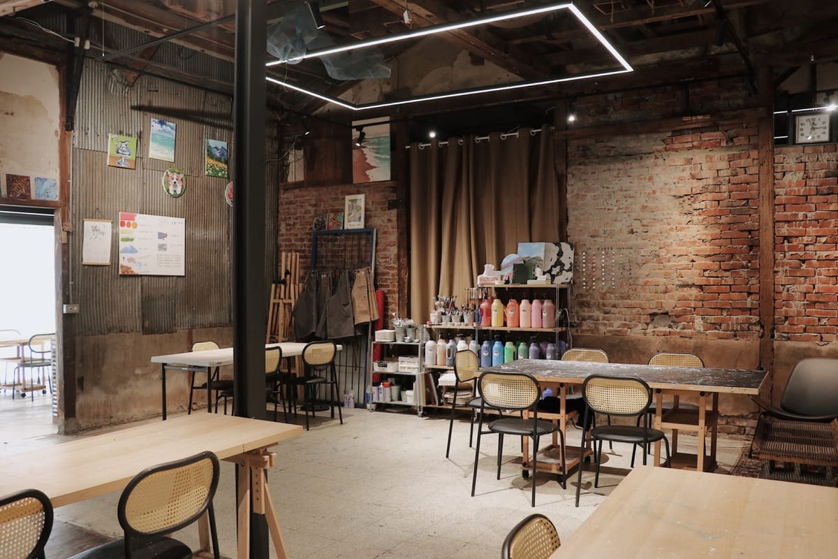 Long tables, chairs, craft materials and paint jars inside Pocket Party's brick interior.