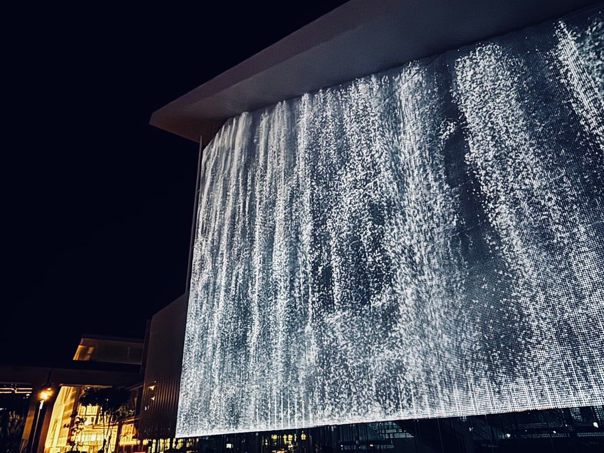 A geometric projection stretches across the Taoyuan Museum of Fine Arts facade at night.
