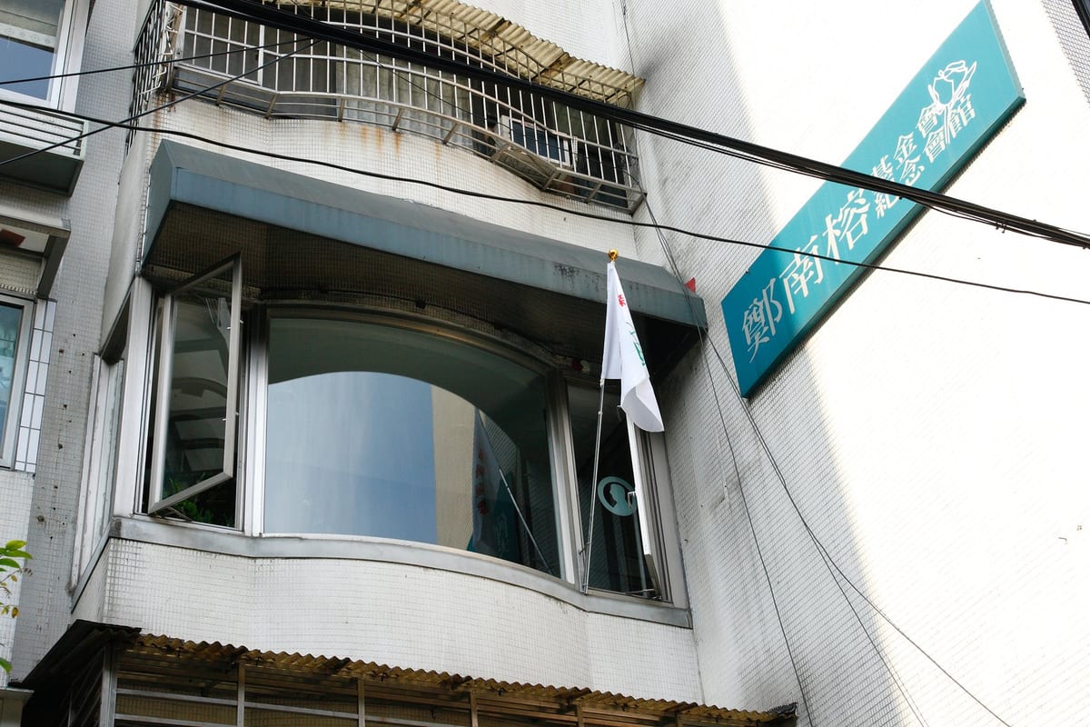 A residential and office block in a lane off Minquan East Road, its upper floor carrying the Nylon Cheng Foundation and memorial museum signs.