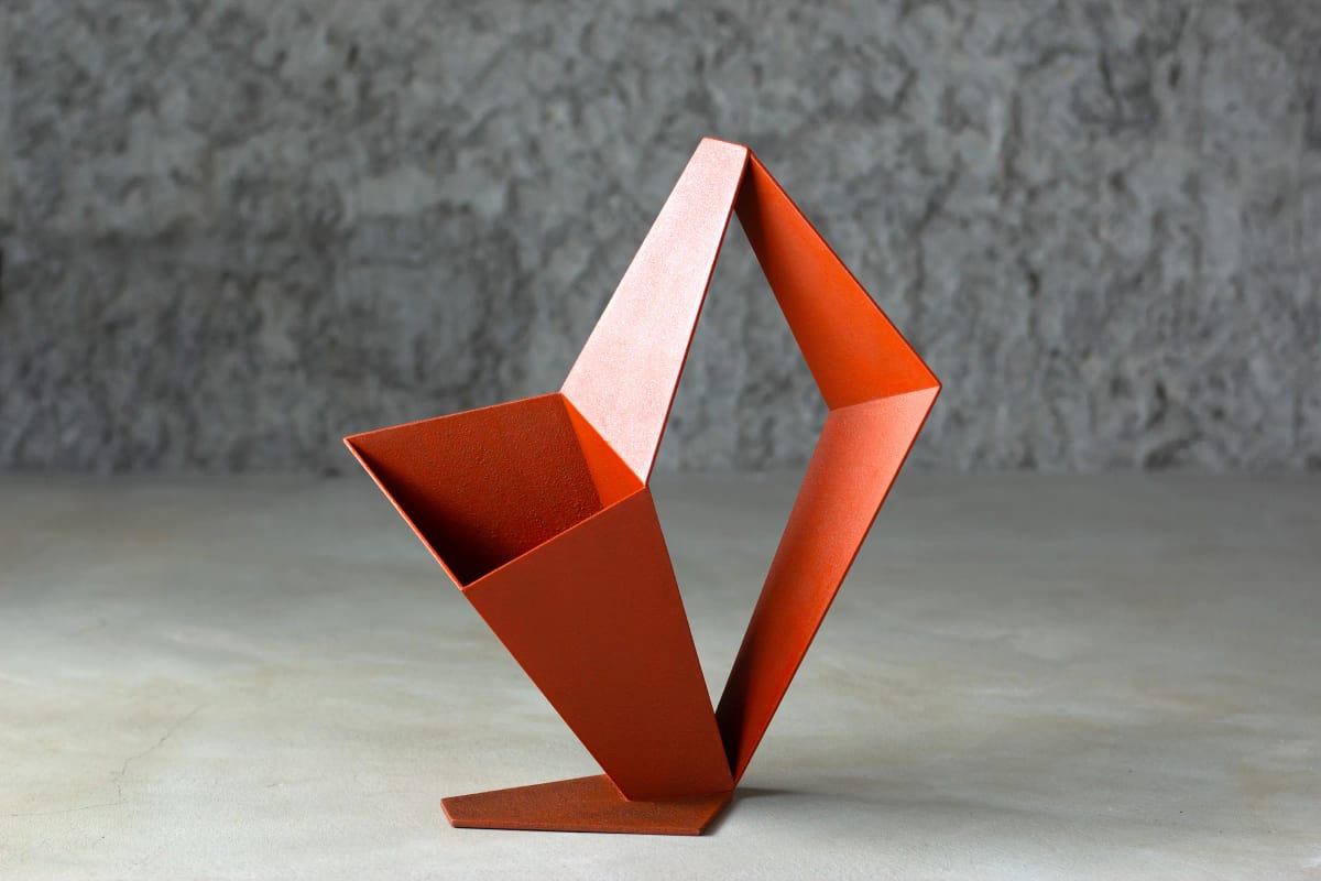 Folded orange-red iron planes enclose two irregular openings above a thin base, one face pale and another deep red.