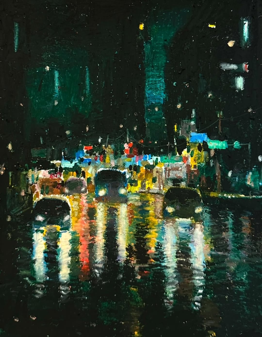 Red, yellow and turquoise headlights and signs reflect across a wet night street, beneath buildings in deep green and black.