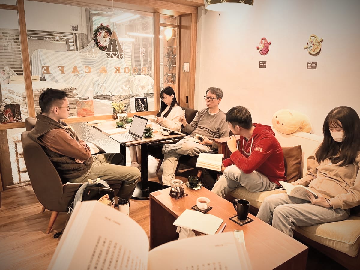 Readers sit around tables at Wen Chao, some reading and others talking.