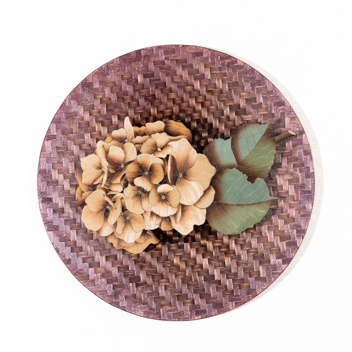 Pale flower heads and green leaves fill a square wooden panel against a purple-brown pattern resembling a weave.