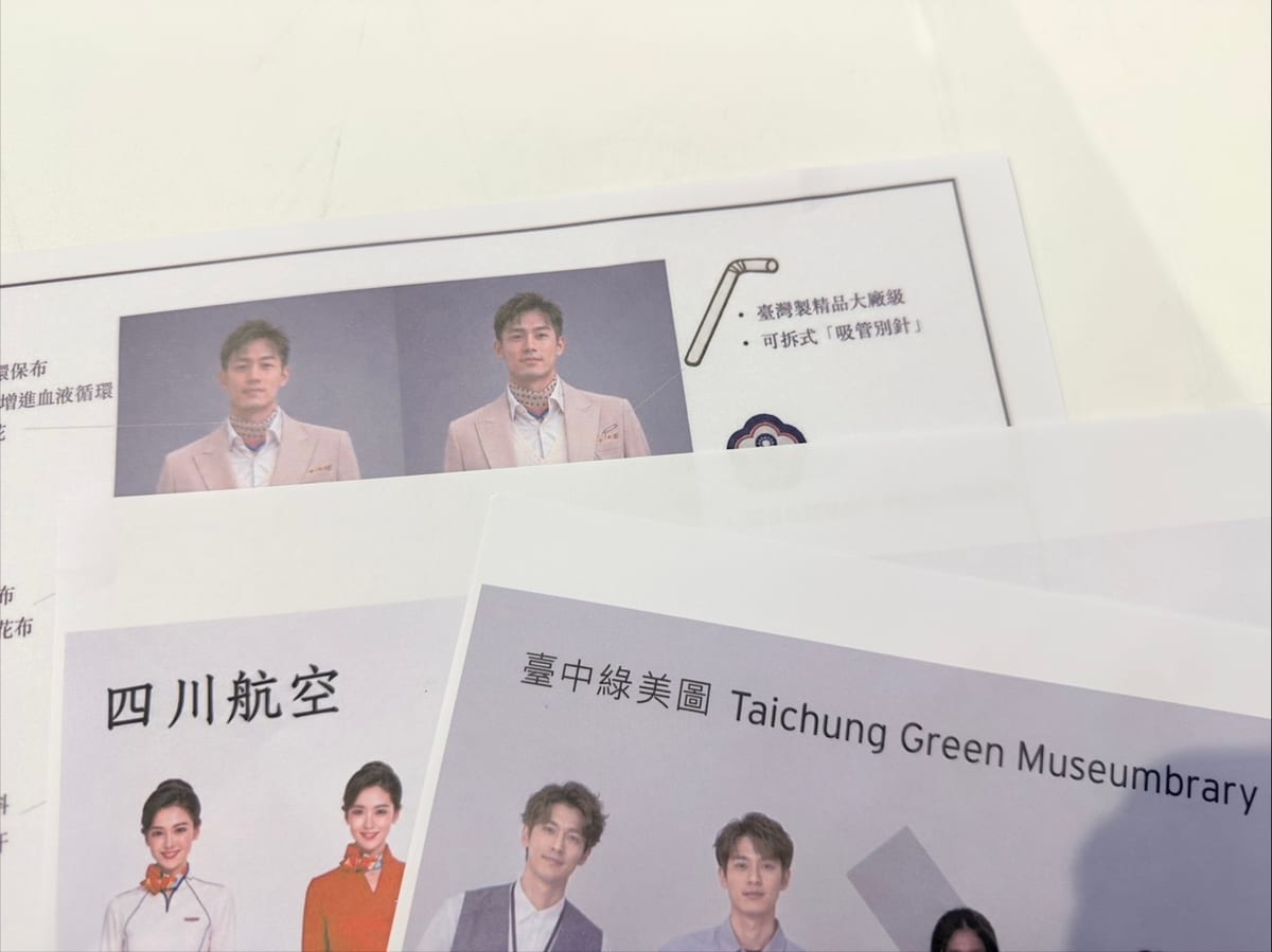 Overlapping uniform proposal sheets show pink suits, orange-and-white tops and a Taichung Green Museumbrary heading. A bendy straw beside the pink suits is labelled as a removable pin.
